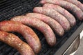 Grilled smoked sausages outdoors. Meat baked on the grill bbq. Meat delicacies. Sausages homemade sausages on the grill. Street fo Royalty Free Stock Photo