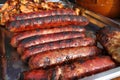 Grilled smoked sausages outdoors. Meat baked on the grill bbq. Meat delicacies. Sausages homemade sausages on the grill. Street fo Royalty Free Stock Photo