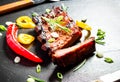 Grilled spareribs on slate plate with cutlery Royalty Free Stock Photo