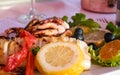 Grilled squid, lemon, olives and wine. Romantic dinner for two by the sea. Warm summer evening