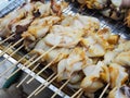 Grilled squid skewers for sale at seafood market.