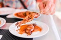 Grilled Squids on wooden sticks on white plate in spicy sause. A dish of Chinese cuisine. Royalty Free Stock Photo