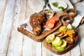 Grilled steak on a cutting board and assorted grilled vegetables. Appetizing grilled meat with vegetables and herbs, sauce. Royalty Free Stock Photo