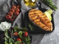 grilled steak fish salmon  trout in a grill pan  spices  fresh salad  tomato  close up Royalty Free Stock Photo