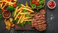 Grilled steak, fries, salad a gourmet barbecue meal Royalty Free Stock Photo