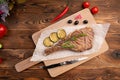 Grilled steak with lemon on a wooden background