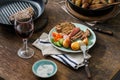 Grilled steak with potatoes, salad on wooden table with wine Royalty Free Stock Photo