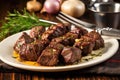 grilled steak tips with garlic on a dinner plate with utensils Royalty Free Stock Photo