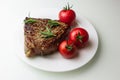 Grilled steak with vegetables on a white plate, seasoned with pepper and rosemary Royalty Free Stock Photo