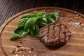 Grilled steak on wooden chopping board with spinach and spices Royalty Free Stock Photo