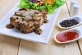 Grilled steaks, pork with pepper gravy and vegetable salad Royalty Free Stock Photo