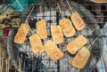 Grilled sticky rice with egg cooking and heat on coal in Luang Prabang local market, Laos. Royalty Free Stock Photo