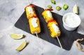 Grilled sweet corn on the sticks, concrete table Royalty Free Stock Photo