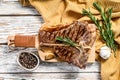 Grilled T bone steak on a chopping Board. Cooked tbone beef. White wooden background. Top view