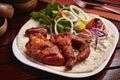 Grilled Tandoori Chicken with bread, salad and lemon served in dish isolated on table side view of middle east food Royalty Free Stock Photo