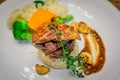 Grilled tenderloin filet mignon medallion with bacon mashed potatoes & seasonal vegetables. Topped with foie gras and served with Royalty Free Stock Photo