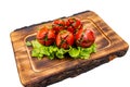 Grilled tomatoes garnished with fresh herbs on a wooden platter