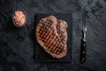 Grilled top sirloin or rump steak on a marble board. Black background. Top view Royalty Free Stock Photo