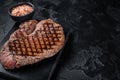 Grilled top sirloin or rump steak on a marble board. Black background. Top view. Copy space Royalty Free Stock Photo