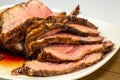 Grilled tri tip steak sliced on a white plate on the kitchen table