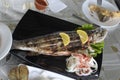 grilled trout fish on the plate with lemon and onion