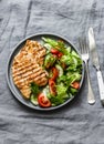 Grilled turkey chops and tomatoes, cucumbers, greens salad on a gray background, top view. Healthy food diet concept Royalty Free Stock Photo