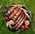 Grilled various food, sausages and vegetable and meat skewers with herbs on a cast iron grill Royalty Free Stock Photo