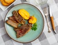 Grilled veal ribs churrasco with baked potatoes and greens Royalty Free Stock Photo