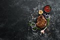 Grilled veal steak with spices on black stone background. Royalty Free Stock Photo
