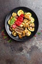 Grilled vegetable salad. Salad of barbecued zucchini, eggplant, sweet pepper, onion and mushrooms on black plate Royalty Free Stock Photo