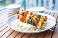 grilled vegetable skewers on a bed of couscous with tzatziki sauce
