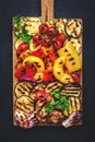 Grilled vegetables: colorful paprika, zucchini, eggplant, mushrooms, tomatoes and onions served on rustic wooden cutting board, Royalty Free Stock Photo