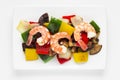 Grilled vegetables hot salad with prawns top view on a white background. Food color and geometry