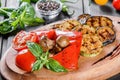 Grilled vegetables, mushrooms, tomatoes, eggplant, pepper on cutting board on wooden background. Royalty Free Stock Photo