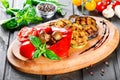Grilled vegetables, mushrooms, tomatoes, eggplant, pepper on cutting board on wooden background Royalty Free Stock Photo