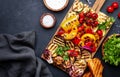 Grilled vegetables on rustic wooden cutting board,: colorful paprika, zucchini, eggplant, mushrooms, tomatoes and red onions with Royalty Free Stock Photo