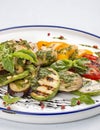 Grilled vegetables - tomatoes, zucchini, eggplant, sweet pepper, mushrooms. In a white plate Royalty Free Stock Photo