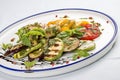 Grilled vegetables - tomatoes, zucchini, eggplant, sweet pepper, mushrooms. In a white plate Royalty Free Stock Photo