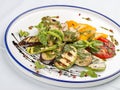 Grilled vegetables - tomatoes, zucchini, eggplant, sweet pepper, mushrooms. In a white plate Royalty Free Stock Photo