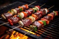 grilled venison steaks with charred vegetable skewers on grill