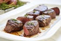 grilled venison steaks on a white ceramic platter