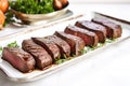 grilled venison steaks on a white ceramic platter