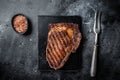 Grilled wagyu Rib Eye steak, marbled beef meat with salt. Black background. Top view