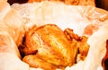 grilled whole chicken with crispy Golden skin on white parchment, top view, close-up