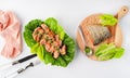 Grilled wild salmon and lettuce dish, linen, cutlery, fish on wooden board on white background, top view Royalty Free Stock Photo