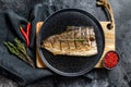 Grilled Yellowtail, Japanese amberjack fillet on a plate. Black background. Top view