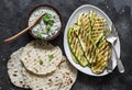 Grilled zucchini, tortillas and tzadziki sauce - delicious greek style snack, tapas on a dark background, top view