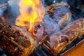 grilling baby back pork ribs over flaming grill Royalty Free Stock Photo