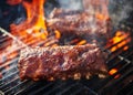Grilling barbecue ribs on flaming grill Royalty Free Stock Photo