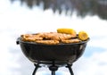 Grilling at the beach. Food cooking on a charcoal kettle grill Royalty Free Stock Photo